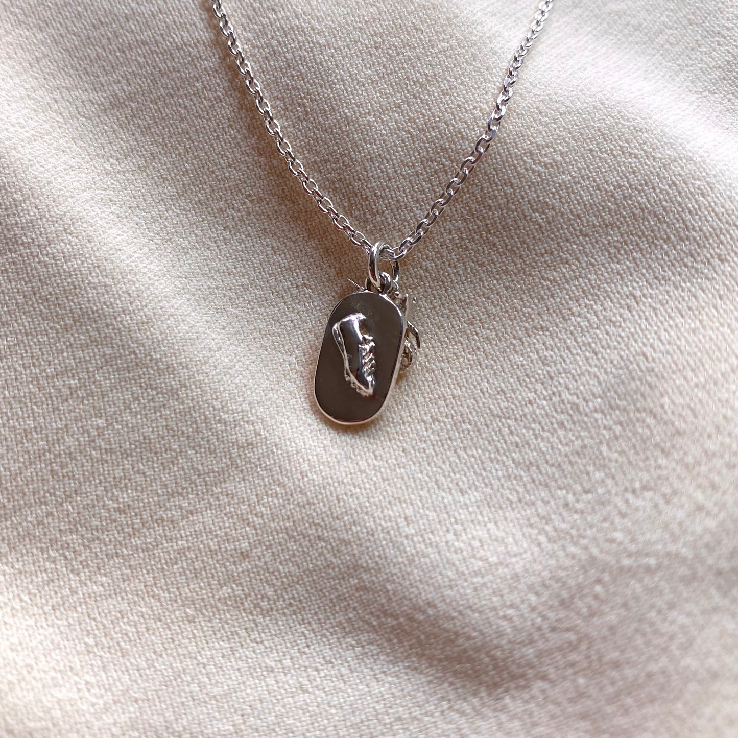 Ciondolo con moto da cross e pista di atletica