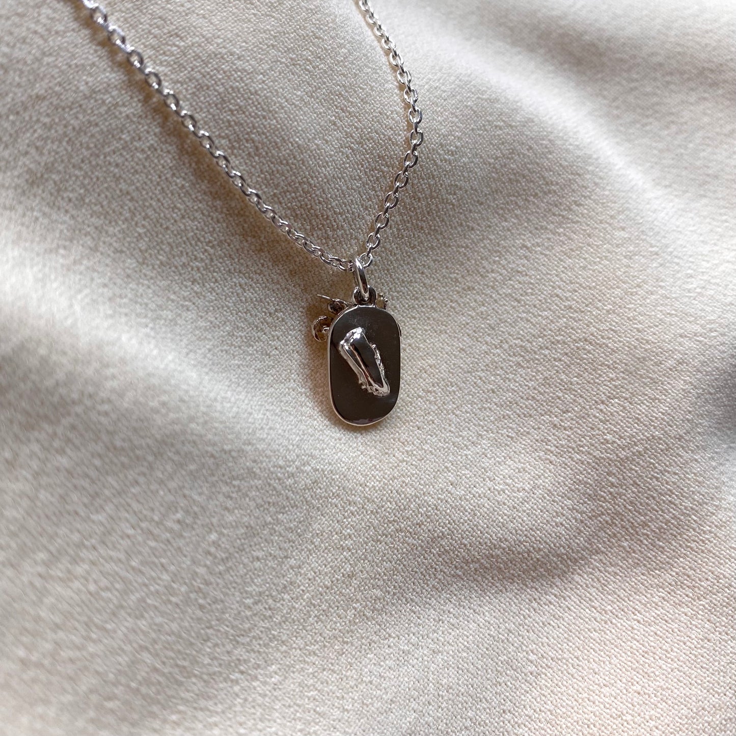 Ciondolo con moto da cross e pista di atletica