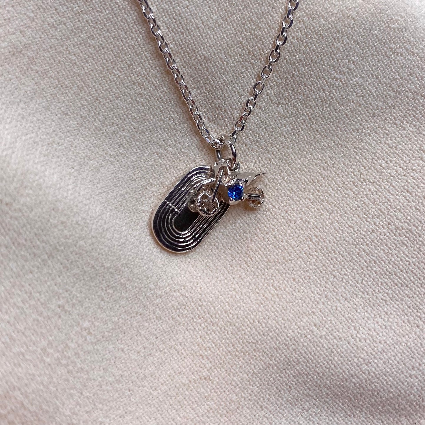 Ciondolo con moto da cross e pista di atletica